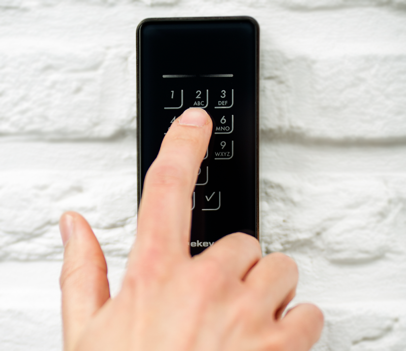 Close-up of hand using keypad access control feature.