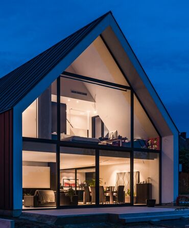  Maison privée avec façade vitrée, beaucoup de lumières la nuit.