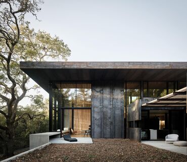 Villa moderne en béton dans une zone boisée.