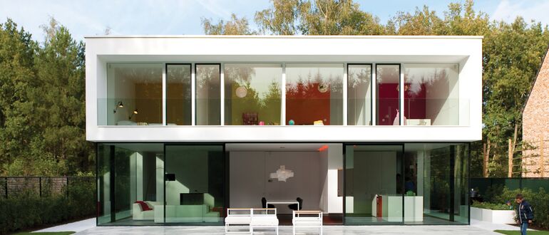 Weiße luxuriöse Villa mit grünem Garten.