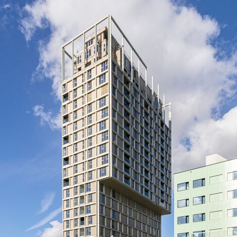 Immeuble de grande hauteur beige avec beaucoup de fenêtres dans le centre-ville.