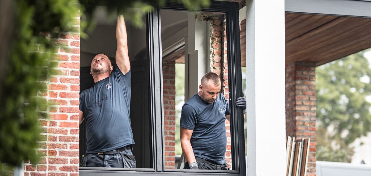 Due installatori che posizionano nuovi profili in alluminio in una casa ristrutturata.