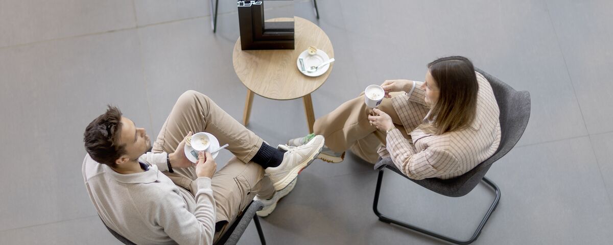 vista dall'alto di uomo e donna seduti a un tavolo, bevendo caffè.