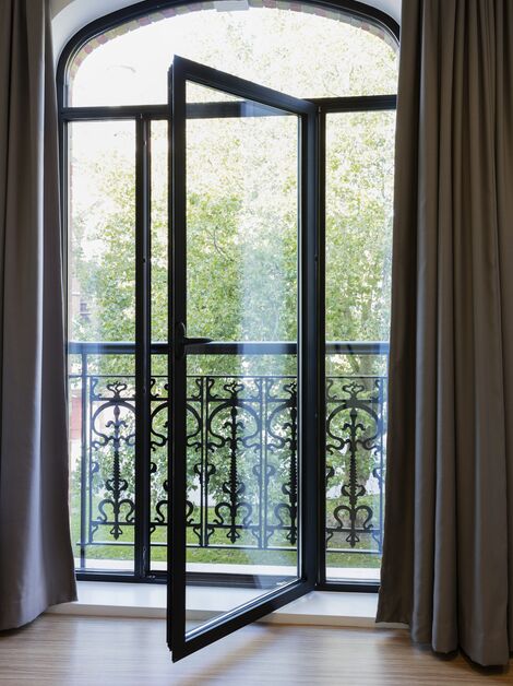 Porte de balcon SlimLine 38 s’ouvrant sur un balcon à la française.