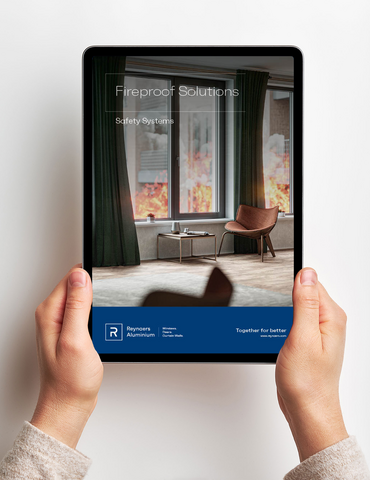 Deux mains tenant l’iPad avec une brochure numérique devant un mur blanc.