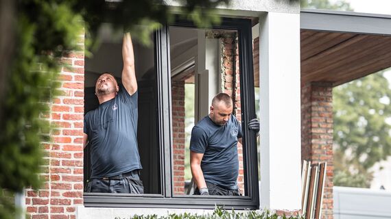 Due installatori che posizionano nuovi profili in alluminio in una casa ristrutturata.