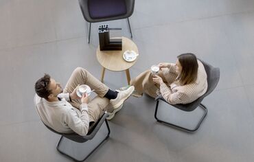 vista dall'alto di uomo e donna seduti a un tavolo, bevendo caffè.