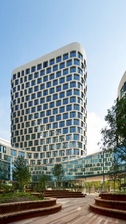 Futuristico edificio per uffici bianco con alberi accanto.